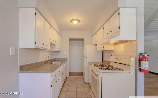 a kitchen with granite countertop a sink and a stove