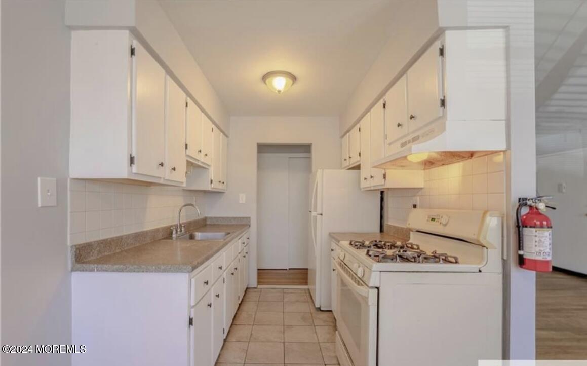 28 Manchester Court, Unit C Freehold, NJ 07728 - Photo 7 of 23 a kitchen with granite countertop a sink and a stove