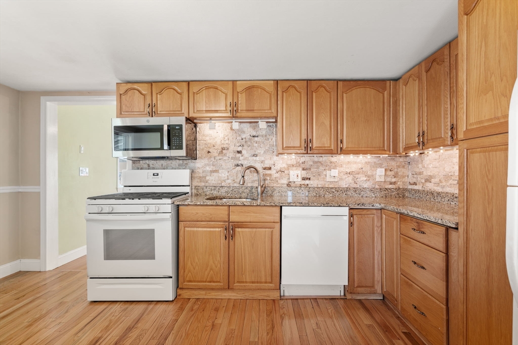 99 Proctor Road Braintree, MA 02184 - Photo 13 of 32 a kitchen with stainless steel appliances granite countertop a stove and white cabinets