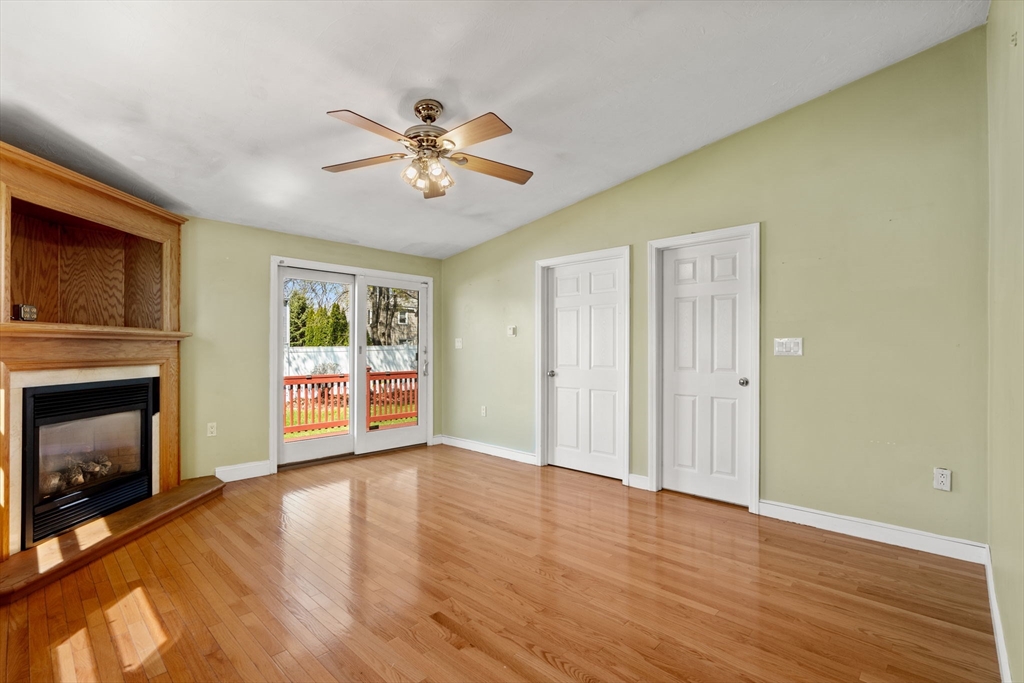 99 Proctor Road Braintree, MA 02184 - Photo 15 of 32 a view of a livingroom with a fireplace a ceiling fan and wooden floor