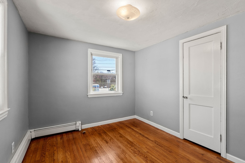 99 Proctor Road Braintree, MA 02184 - Photo 23 of 32 an empty room with wooden floor and windows