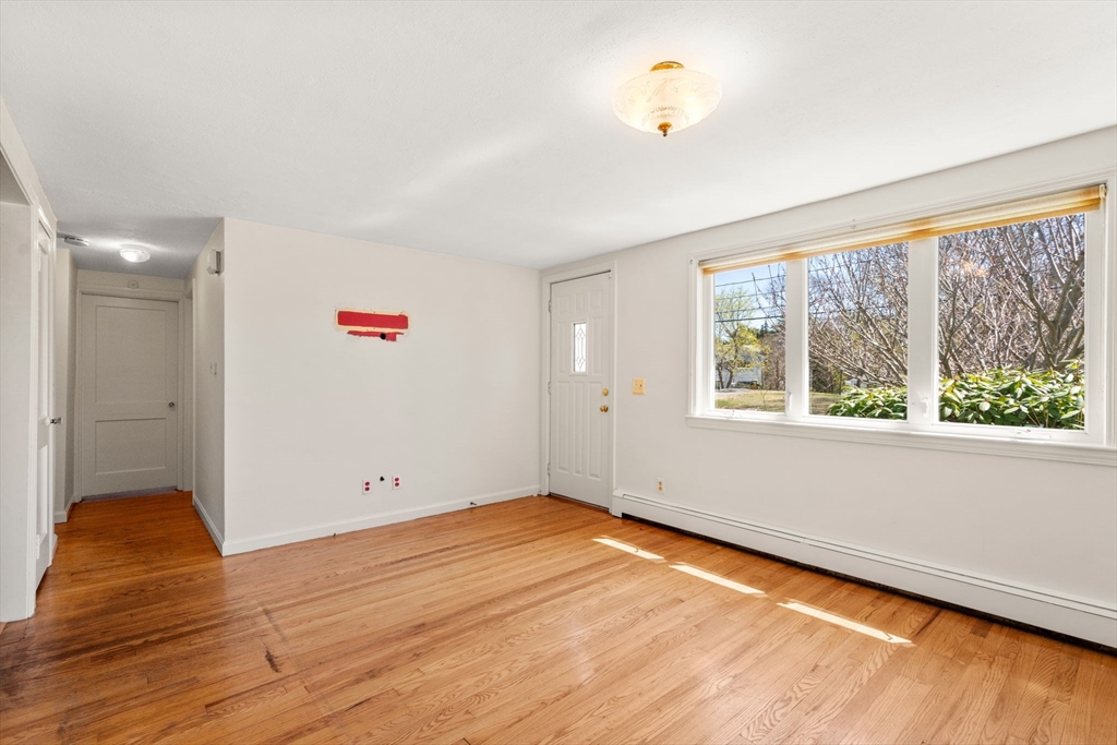 99 Proctor Road Braintree, MA 02184 - Photo 8 of 32 an empty room with wooden floor and windows