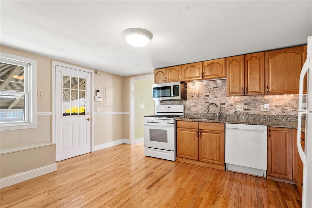 99 Proctor Road Braintree, MA 02184 - Photo 9 of 32 a kitchen with stainless steel appliances granite countertop a stove cabinets and wooden floor