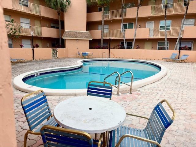3110 North Pine Island Road, Unit 101 Sunrise, FL 33351 - Photo 13 of 14 a view of a swimming pool with a lounge chair