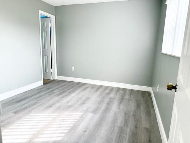 3110 North Pine Island Road, Unit 101 Sunrise, FL 33351 - Photo 9 of 14 an empty room with wooden floor and windows