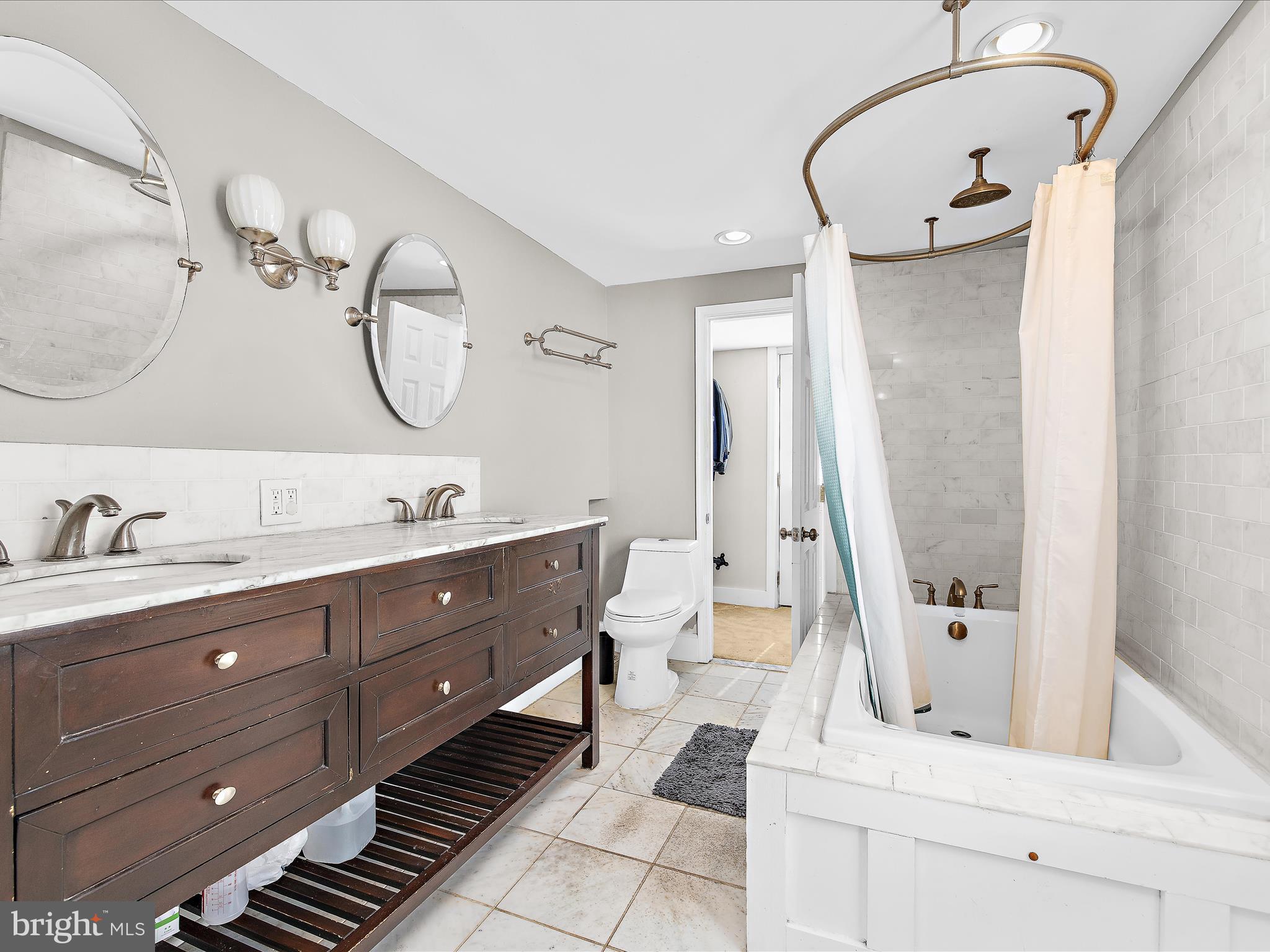 1313 Patapsco Street Baltimore, MD 21230 - Photo 17 of 30 a bathroom with a double vanity sink mirror and bathtub