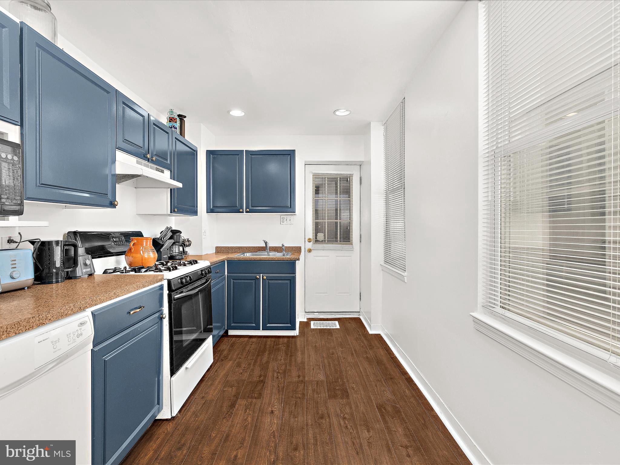 1313 Patapsco Street Baltimore, MD 21230 - Photo 7 of 30 a kitchen with stainless steel appliances granite countertop a refrigerator a sink dishwasher a stove and white countertops with wooden floor
