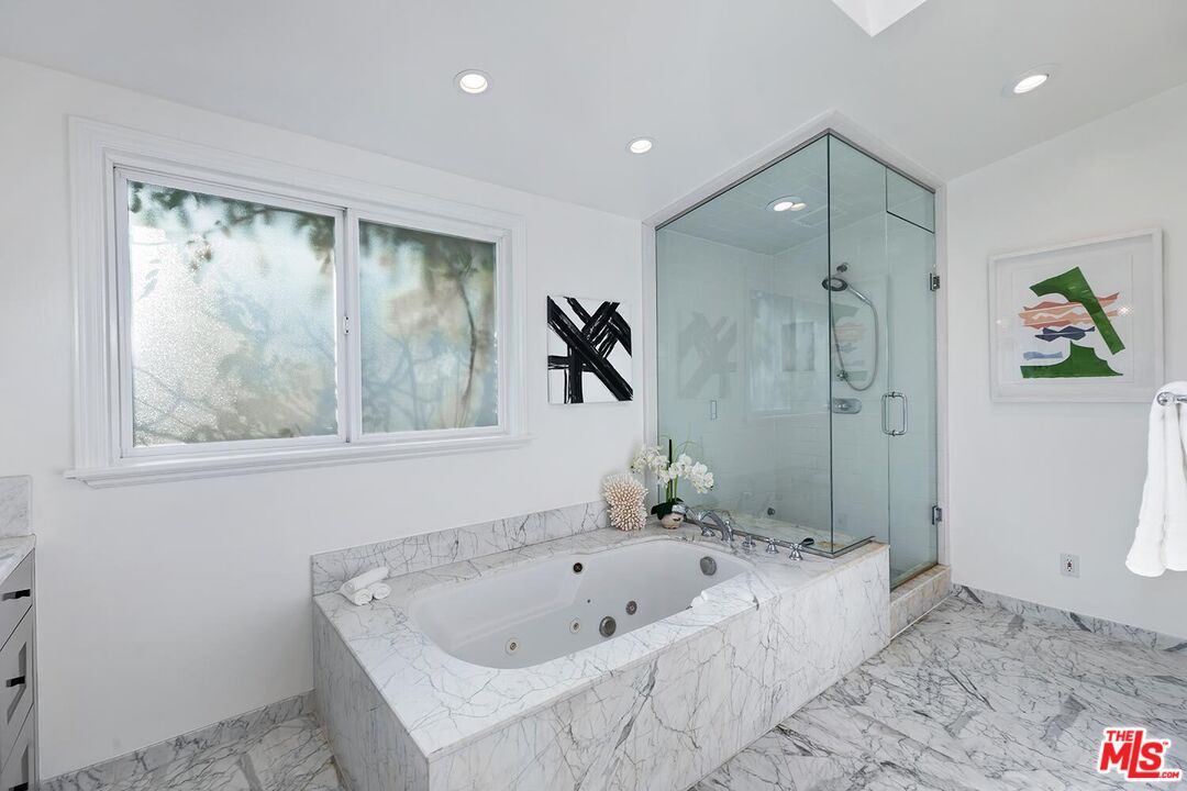 18106 Wakecrest Drive Malibu, CA 90265 - Photo 15 of 29 a bathroom with a tub a sink and glass door shower