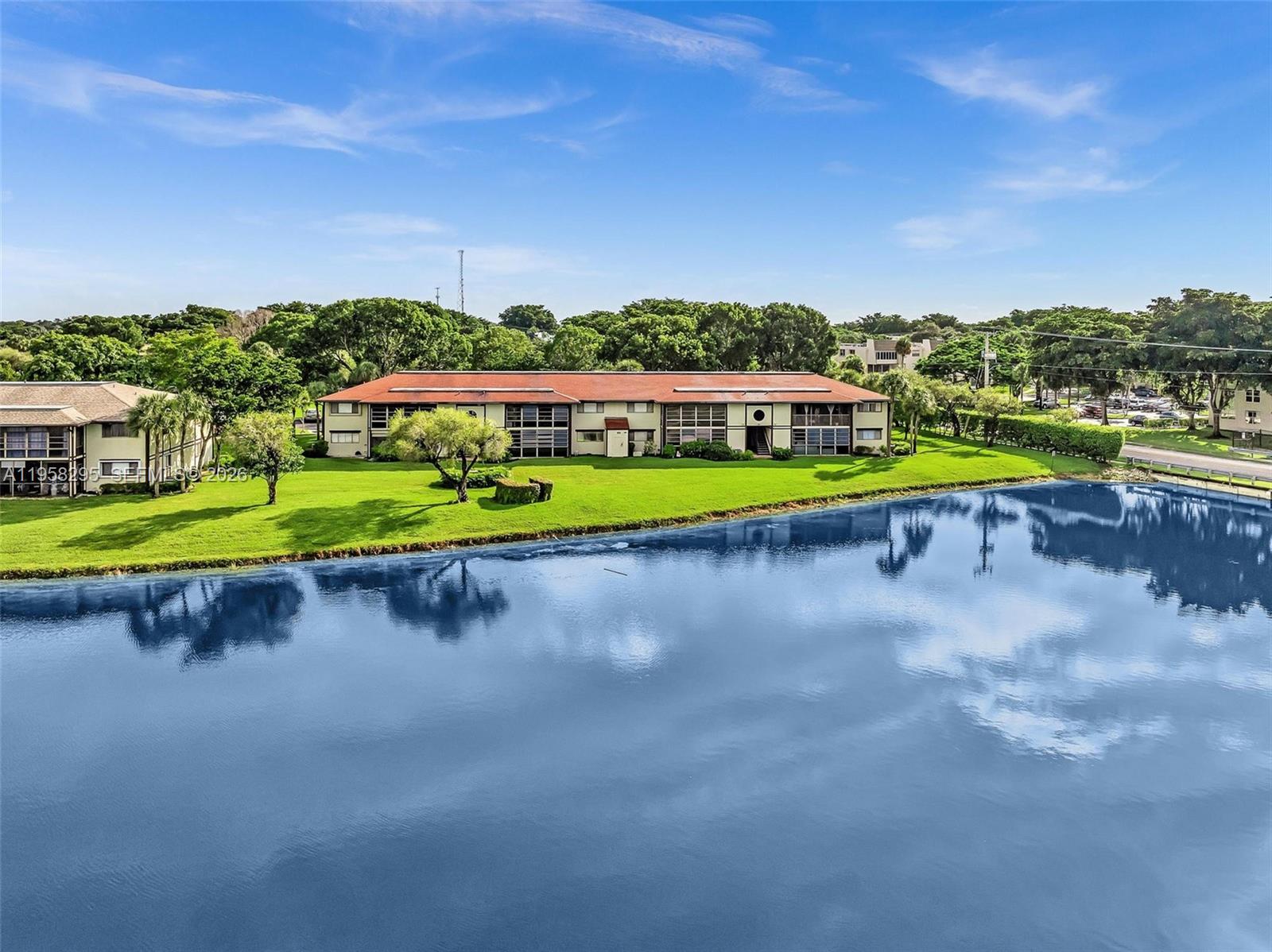 9487 West McNab Road, Unit 205 Tamarac, FL 33321 - Photo 30 of 44 a view of a lake with houses in the back