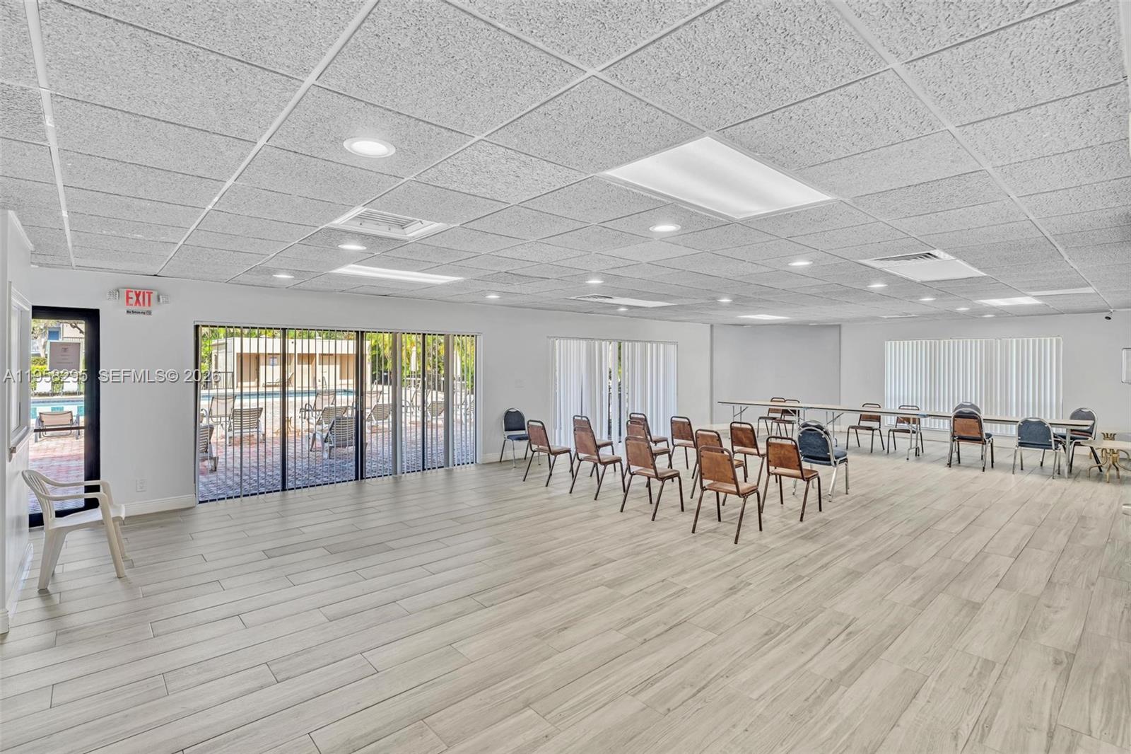 9487 West McNab Road, Unit 205 Tamarac, FL 33321 - Photo 39 of 44 a room with lots of furniture and wooden floors