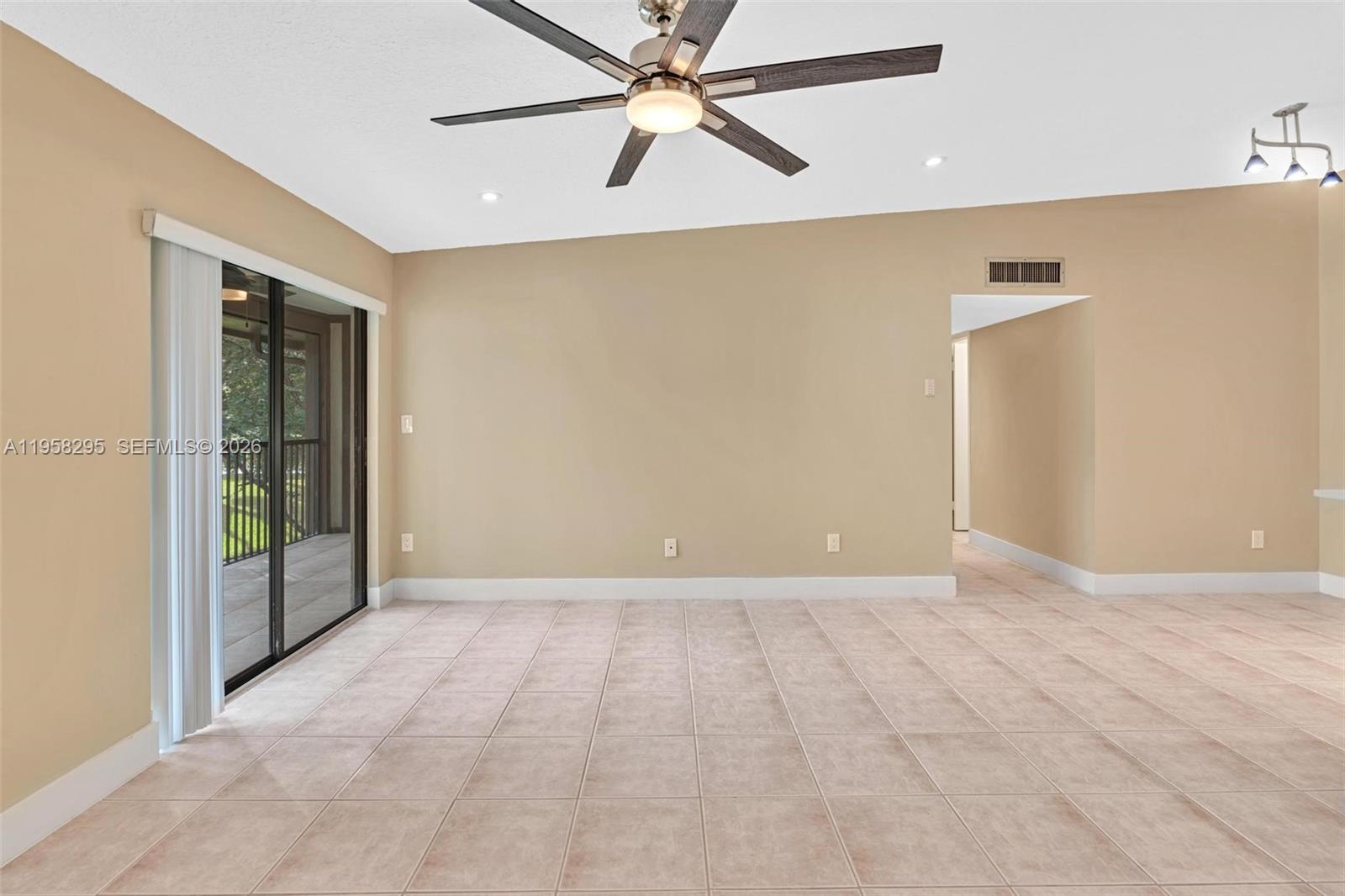 9487 West McNab Road, Unit 205 Tamarac, FL 33321 - Photo 6 of 44 en empty room with windows and ceiling fan