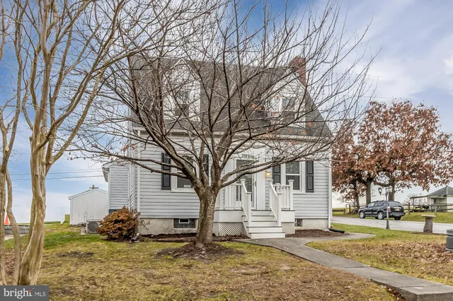 a front view of a house with a yard covered with snow