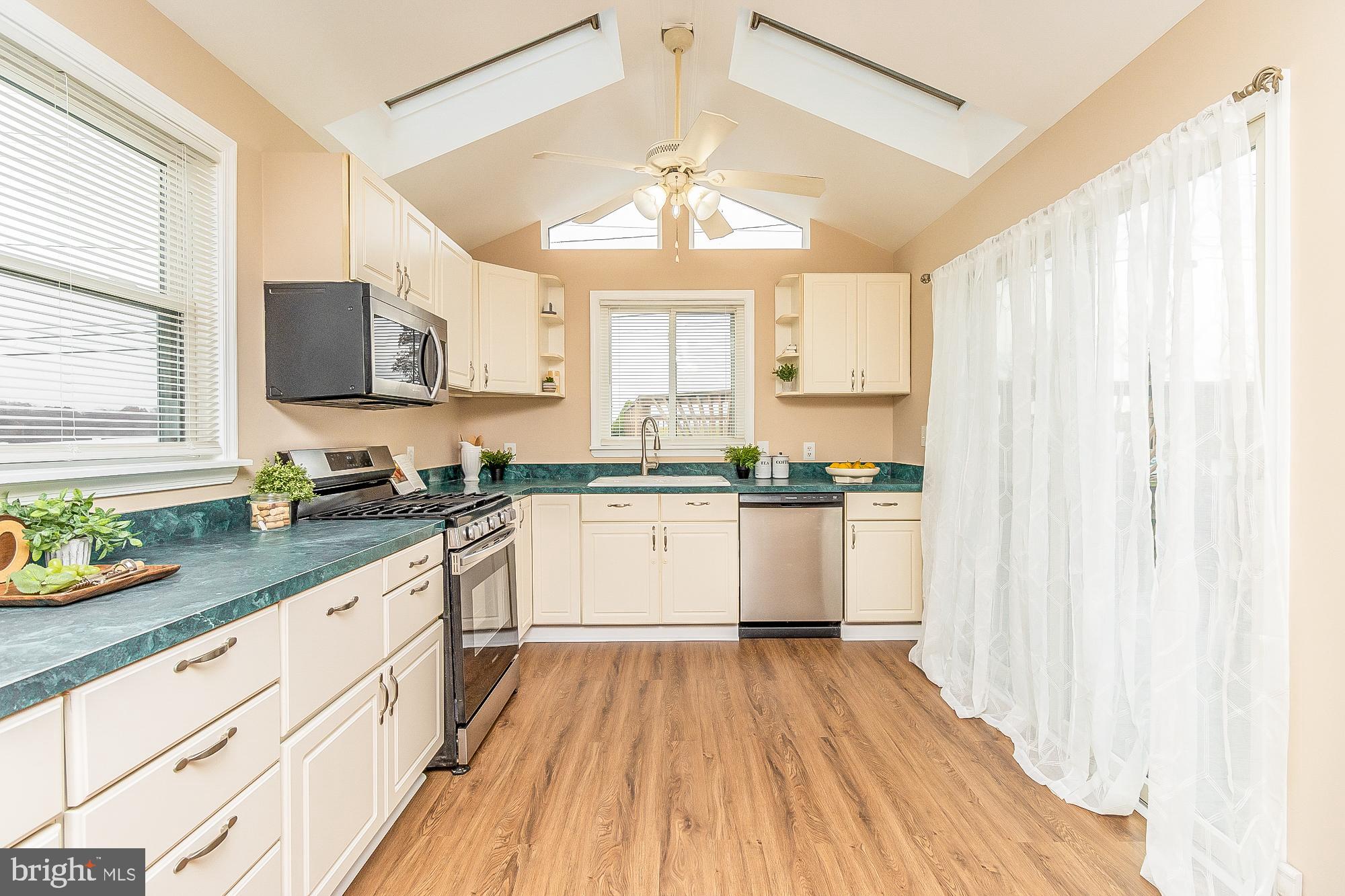 7501 Kenlea Avenue Nottingham, MD 21236 - Photo 27 of 55 a large white kitchen with granite countertop a lot of counter space and wooden floor