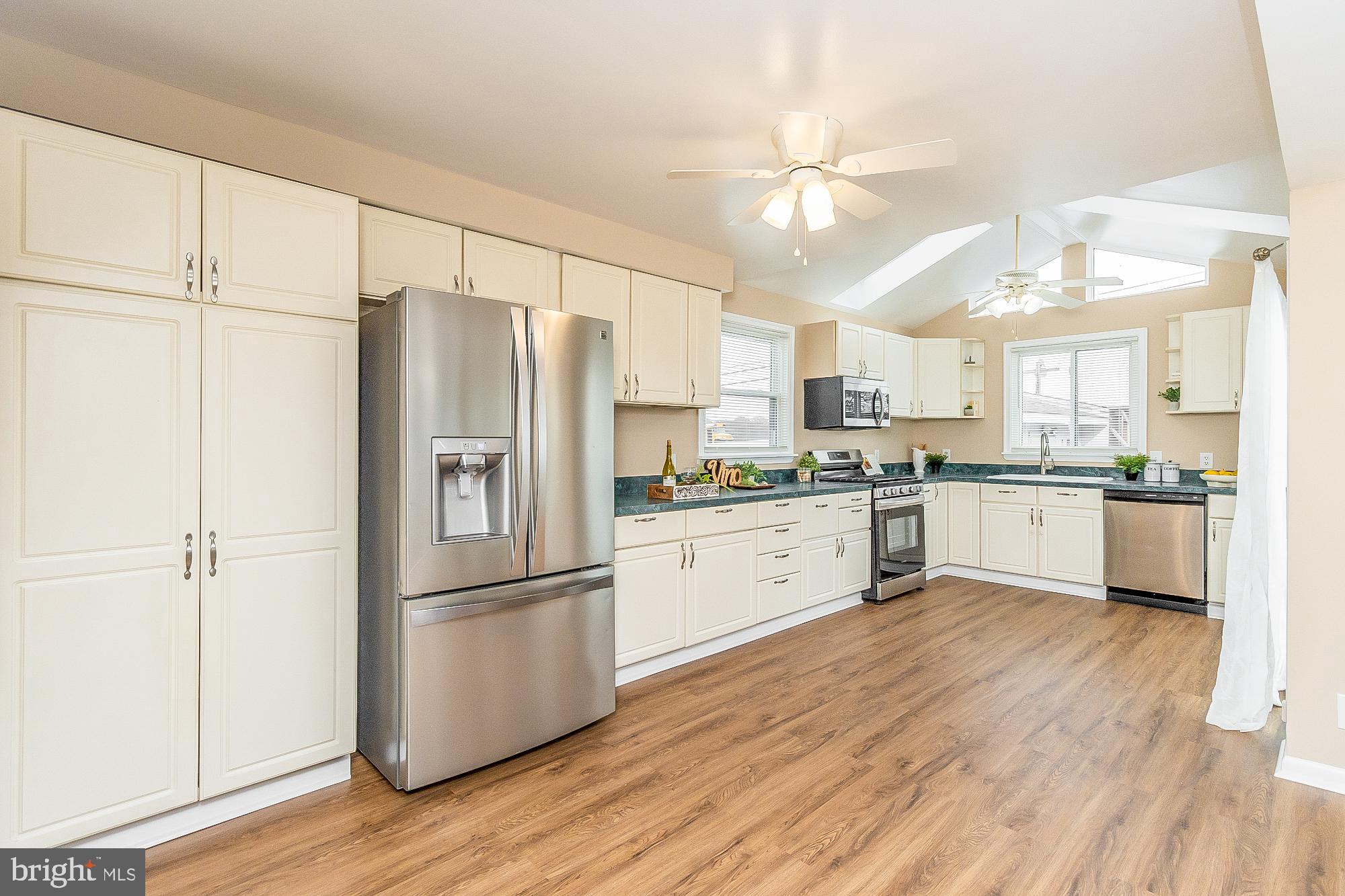 7501 Kenlea Avenue Nottingham, MD 21236 - Photo 28 of 55 a kitchen with a refrigerator a sink and cabinets