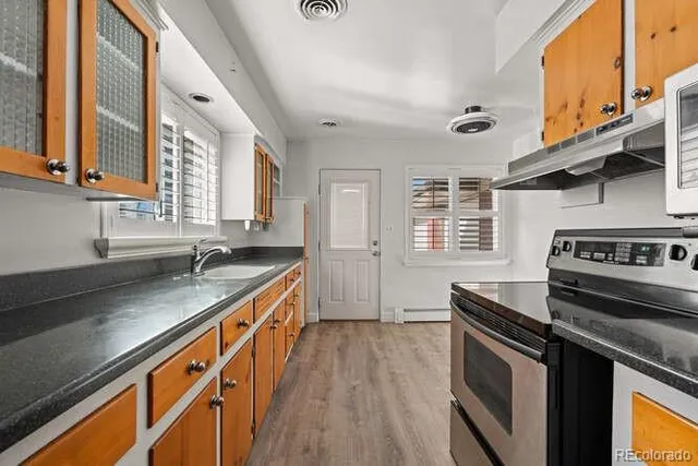 a kitchen with stainless steel appliances granite countertop a stove a sink and a refrigerator