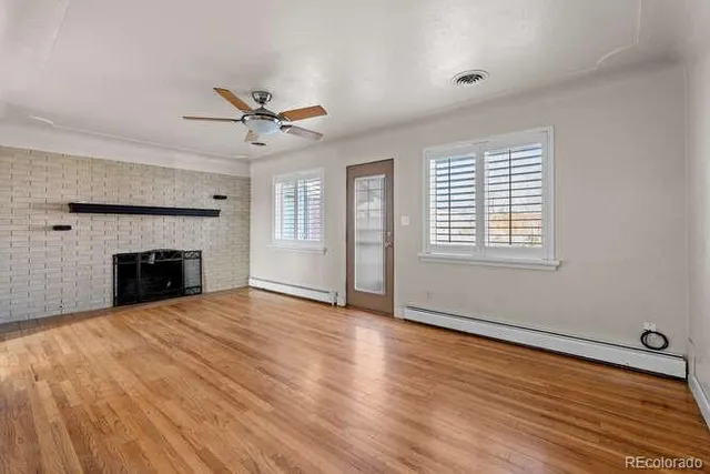 wooden floor fireplace and windows in an empty room