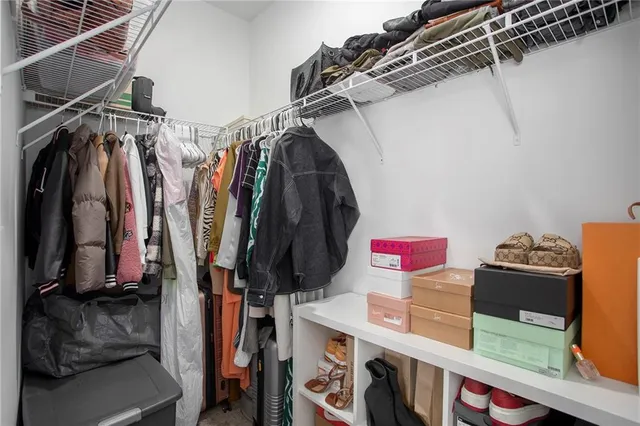 a view of walk in closet with clothes and shoes
