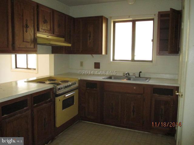 213 Windjammer Road Berlin, MD 21811 - Photo 8 of 10 a kitchen with stainless steel appliances granite countertop a sink stove and cabinets