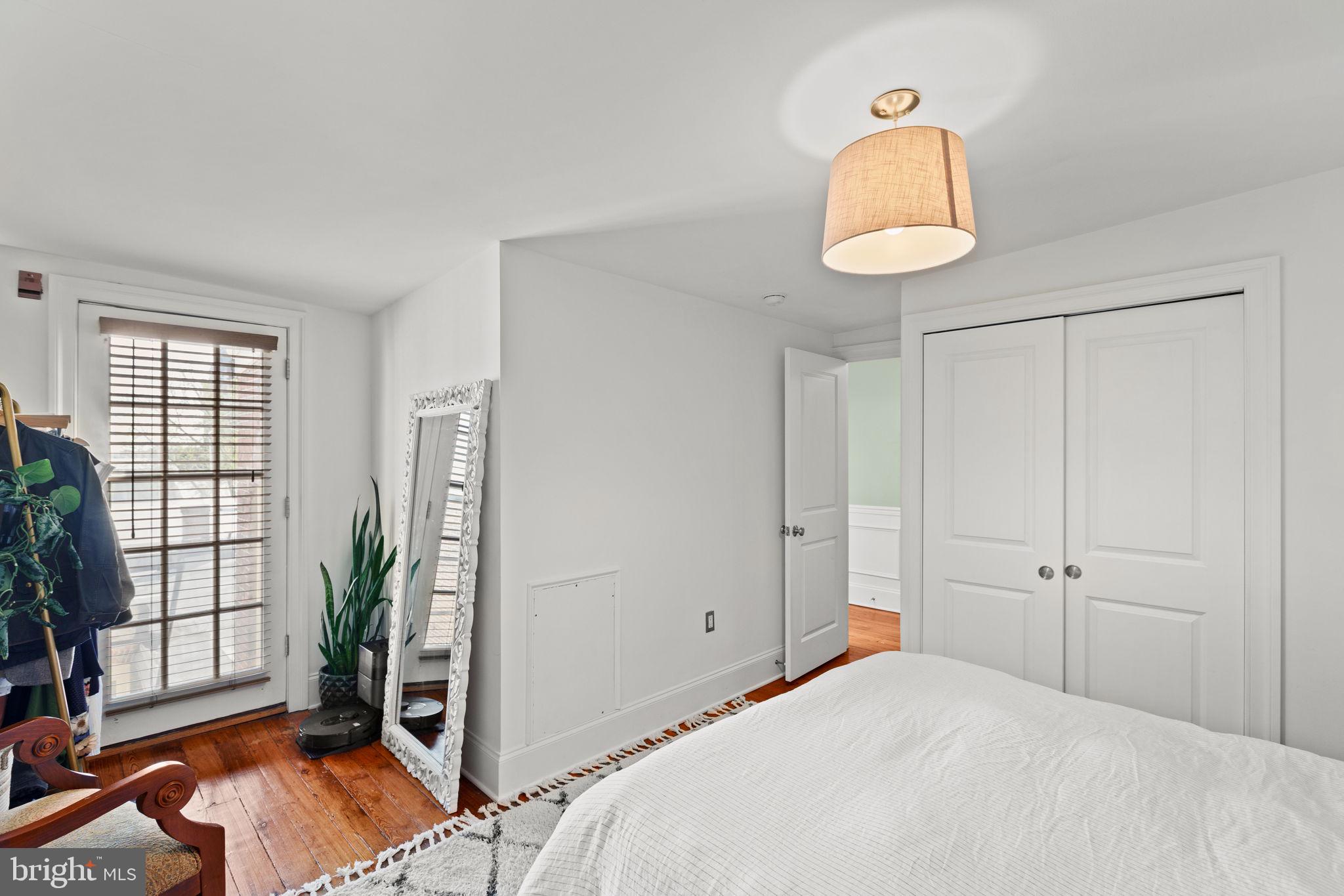 1708 Pine Street, Unit 4F Philadelphia, PA 19103 - Photo 11 of 16 a bedroom with a bed and a potted plant next to a window
