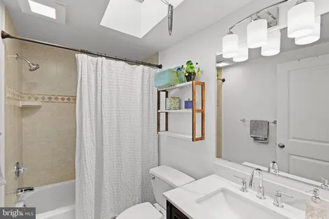 a bathroom with a sink mirror and a shower