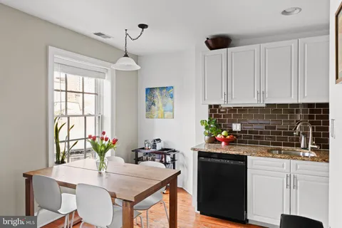 a kitchen with stainless steel appliances a sink stove and white cabinets