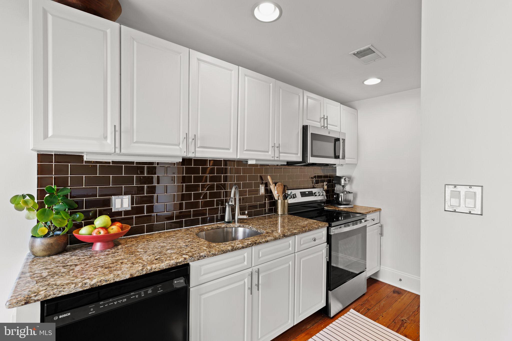 1708 Pine Street, Unit 4F Philadelphia, PA 19103 - Photo 6 of 16 a kitchen with stainless steel appliances granite countertop a sink a stove a microwave and cabinets