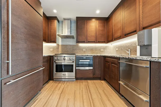 a kitchen with granite countertop stainless steel appliances and wooden cabinets