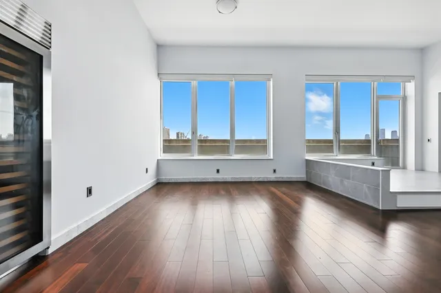 a view of a kitchen with wooden floor and a window