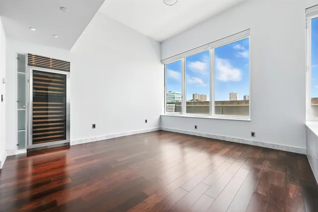 a view of a big room with wooden floor and windows