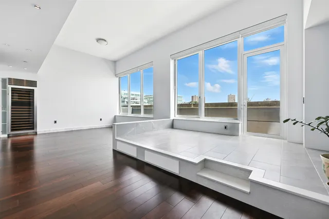 a living room with hard wood floors and a large window