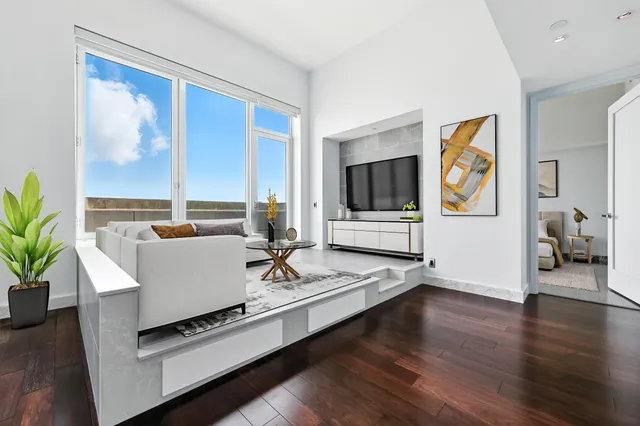 a living room with furniture a flat screen tv and a large window