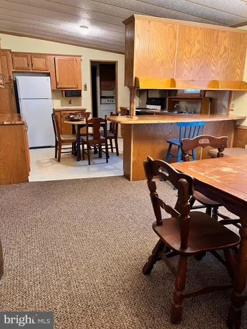 a dining room with furniture window and a kitchen view