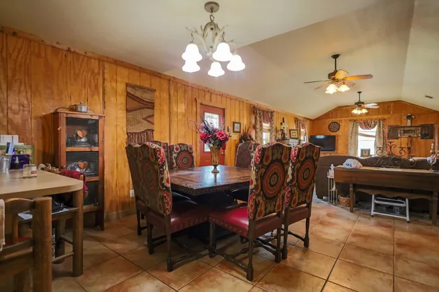 a bedroom with a bed a chandelier and flat screen tv