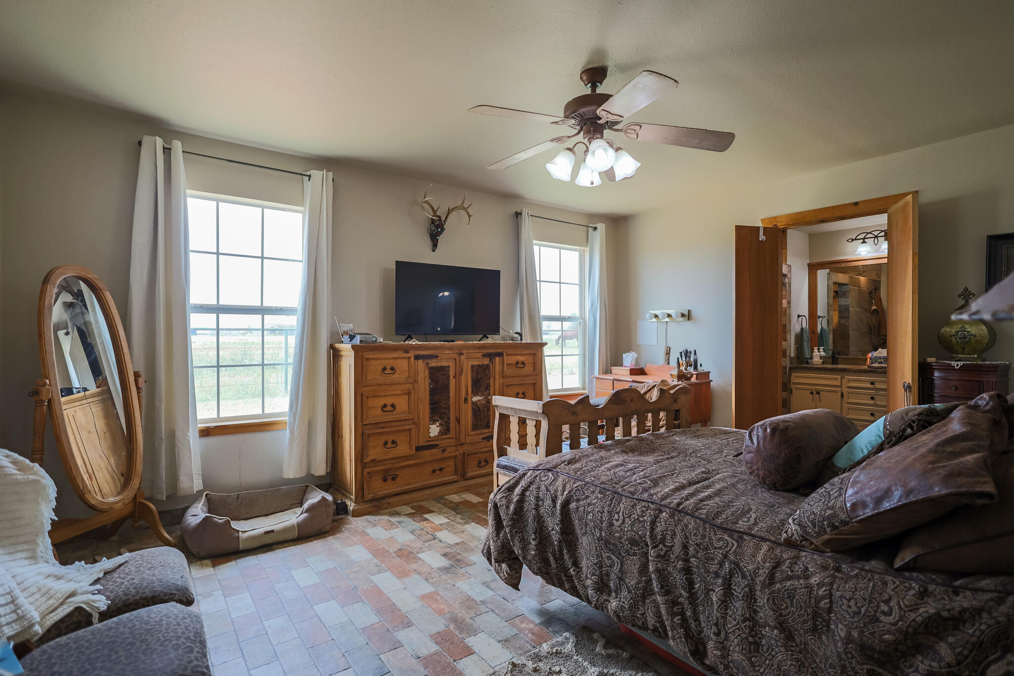 3401 East Regis Street Lubbock, TX 79403 - Photo 18 of 65 a bedroom with a bed a chandelier and flat screen tv