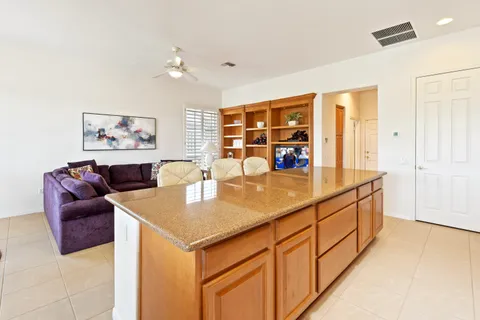 a living room with stainless steel appliances kitchen island granite countertop furniture and a large window