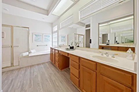 a large bathroom with a double vanity sink a mirror and a bathtub
