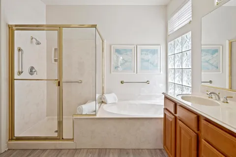 a bathroom with a tub sink and mirror