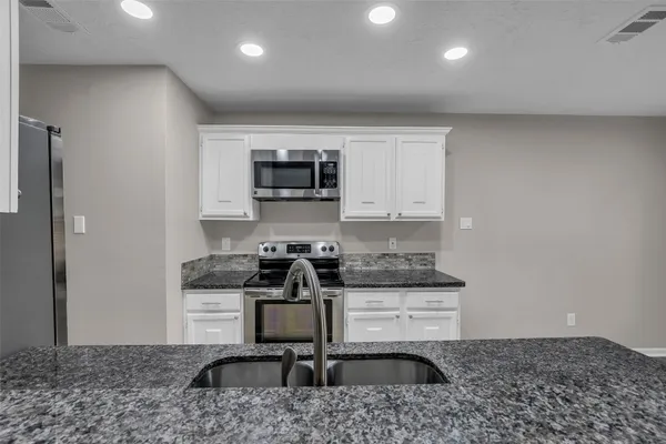 a kitchen with a stove a sink and a microwave