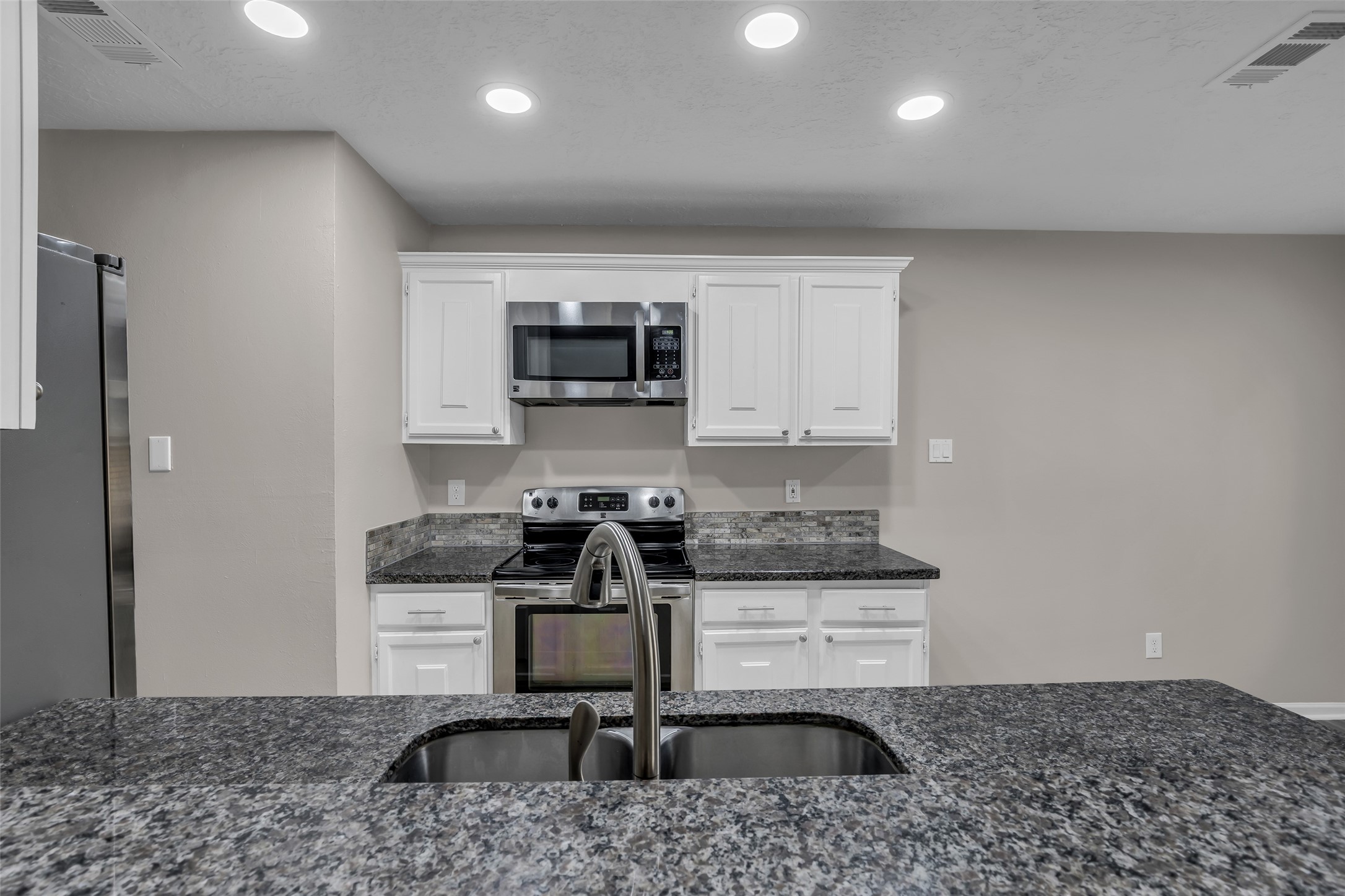 8 Still Glen Court Spring, TX 77381 - Photo 12 of 23 a kitchen with a stove a sink and a microwave
