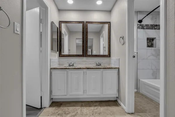 a bathroom with a granite countertop sink and a mirror