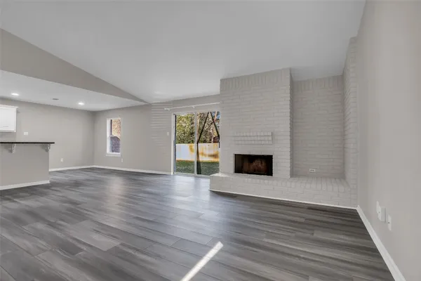 a view of a livingroom with wooden floor and a fireplace