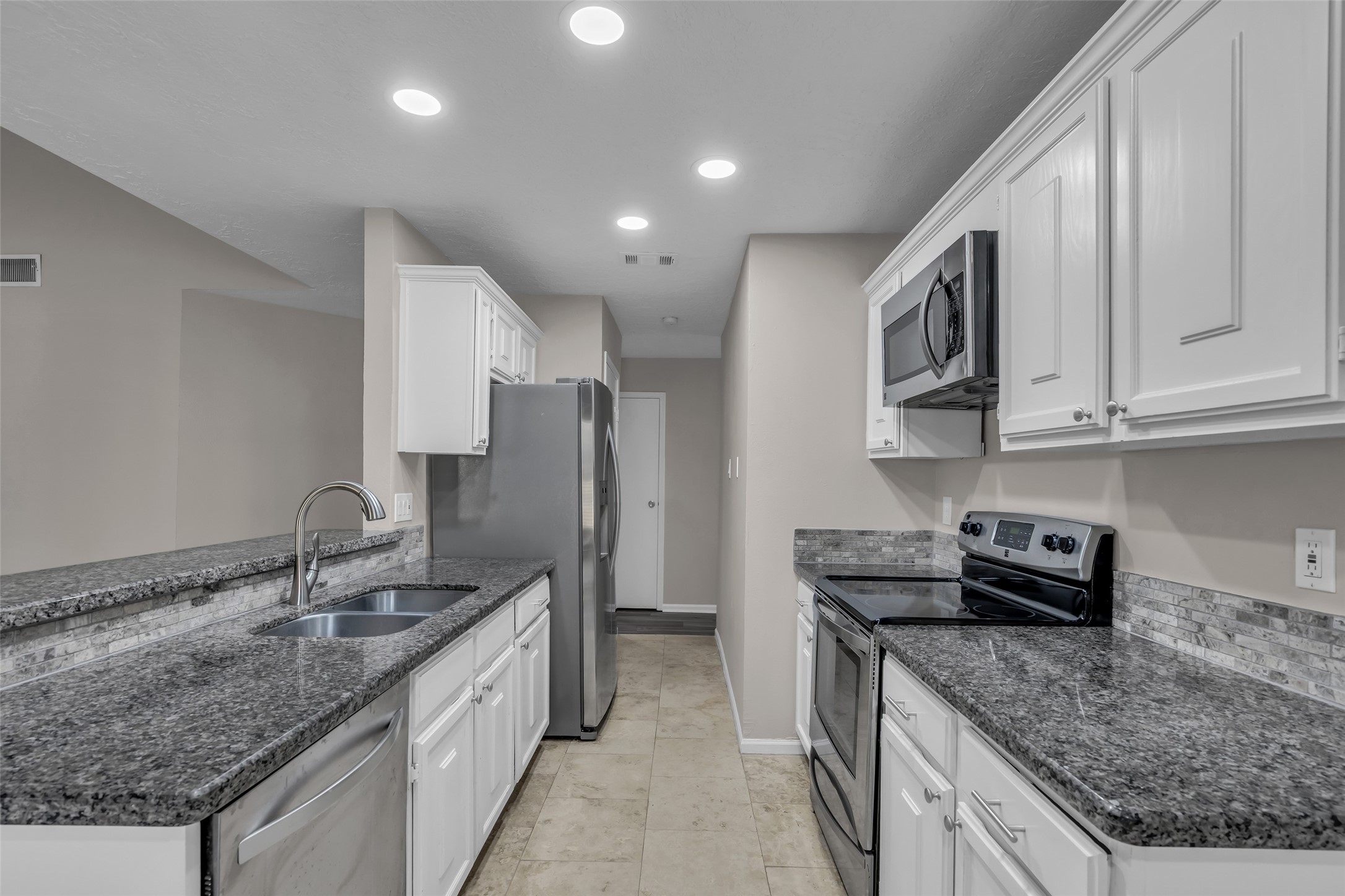 8 Still Glen Court Spring, TX 77381 - Photo 9 of 23 a kitchen with stainless steel appliances granite countertop a sink stove and refrigerator