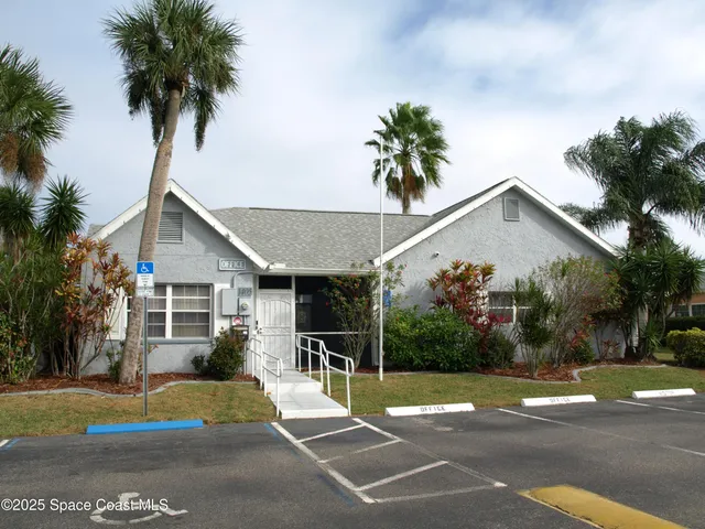 a view of a house with backyard and trees