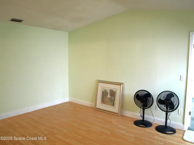 a view of a room with wooden floor and mirrors