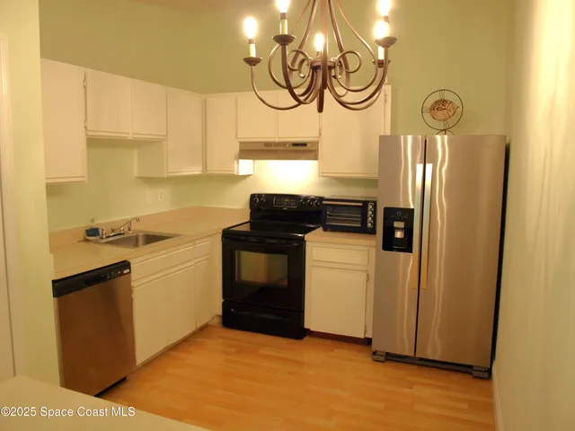 a kitchen with a stove cabinets and a wooden floor
