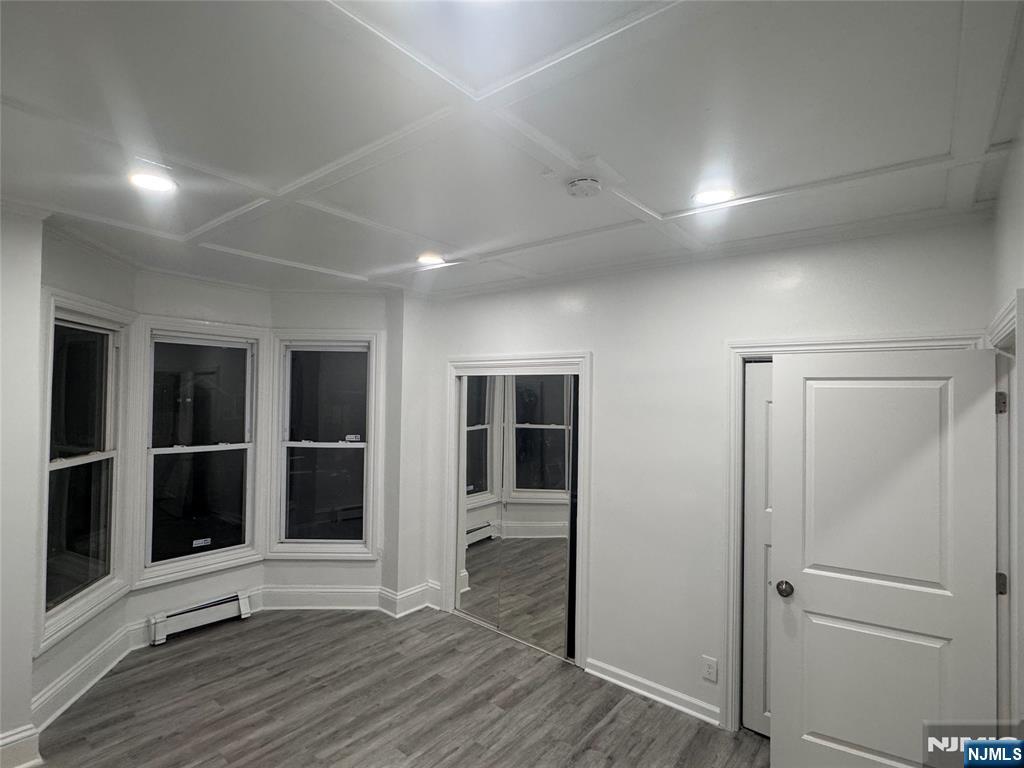 121-123 Butler Street, Unit 121 Paterson, NJ 07524 - Photo 2 of 6 an empty room with wooden floor and windows