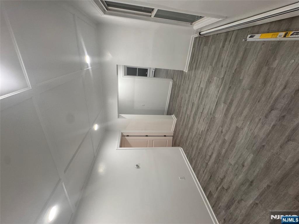 121-123 Butler Street, Unit 121 Paterson, NJ 07524 - Photo 4 of 6 a view of an empty room with wooden floor and a window