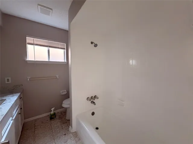 a bathroom with a bathtub and toilet