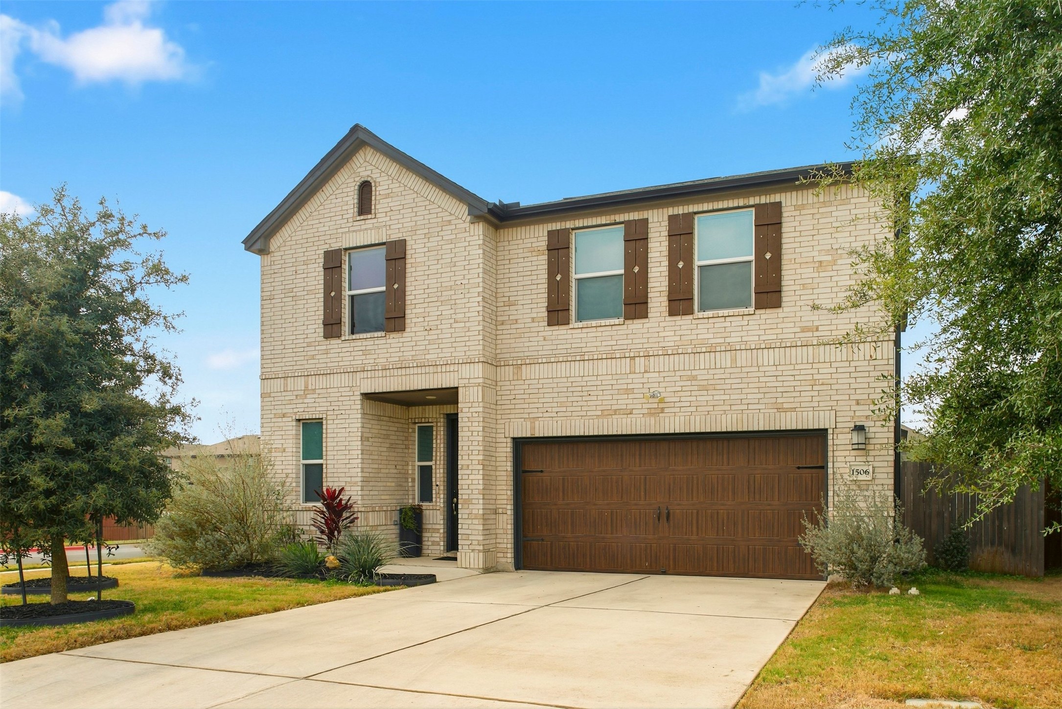 1506 Dragonfly Loop Bastrop, TX 78602 - Photo 1 of 28 View of front of home featuring brick siding, an attached garage, and concrete driveway