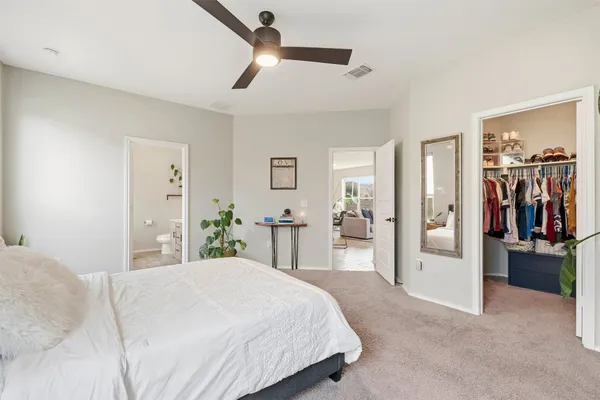 a bedroom with a large bed and a chandelier